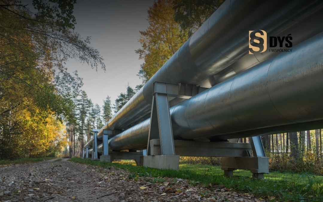 Rurociąg przesyłowy poprowadzony nad ziemią przez teren leśny, element infrastruktury technicznej związanej ze służebnością przesyłu.