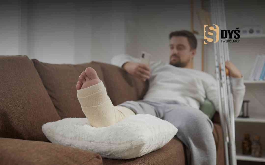 Mężczyzna ze złamaną nogą w gipsie odpoczywa na kanapie i sprawdza telefon.