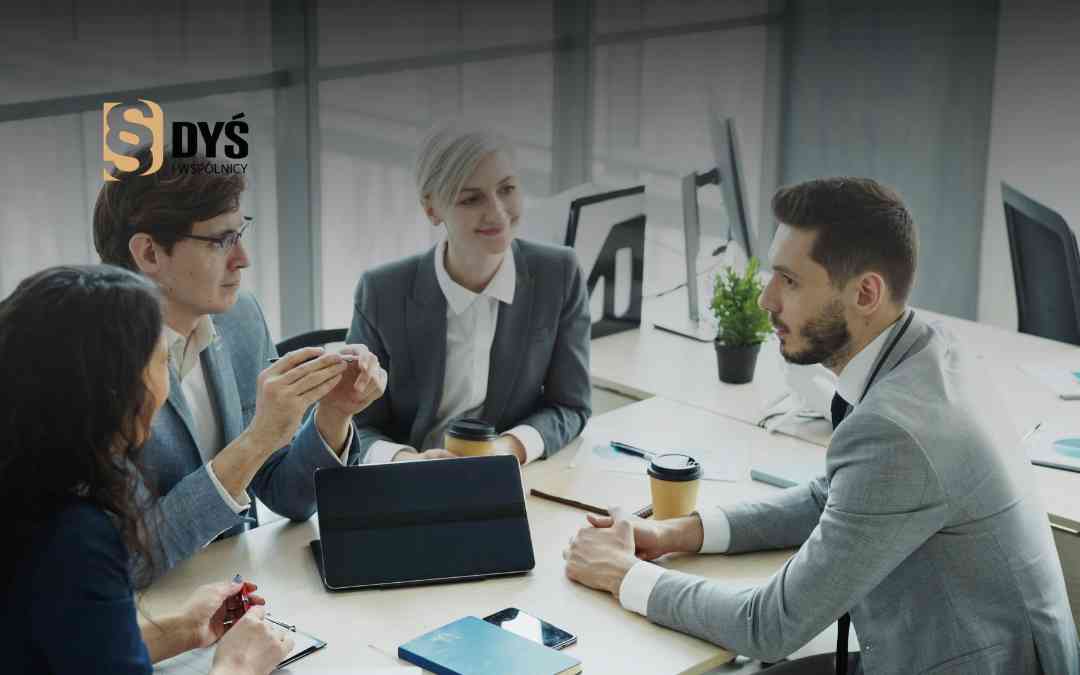 Zespół przedsiębiorców omawia proces przekształcenia spółki przy stole w biurze – doradztwo biznesowe.