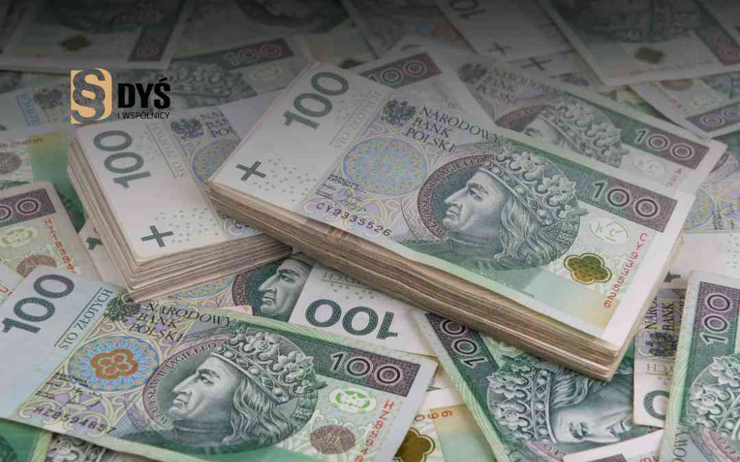 Banknoty o nominale sto złotych ułożone w grube pliki na tle luźnych pieniędzy.