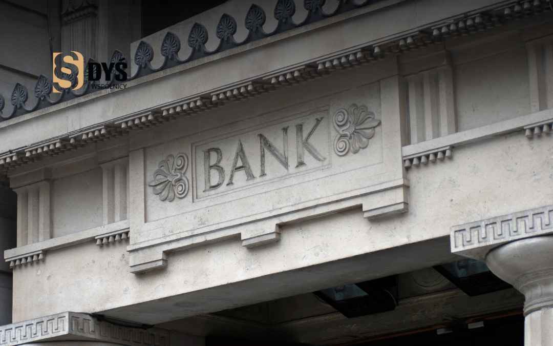 Kamienny szyld z wyrytym napisem BANK i elementami architektonicznymi – ilustracja do artykułu o sporach z bankami o SKD.