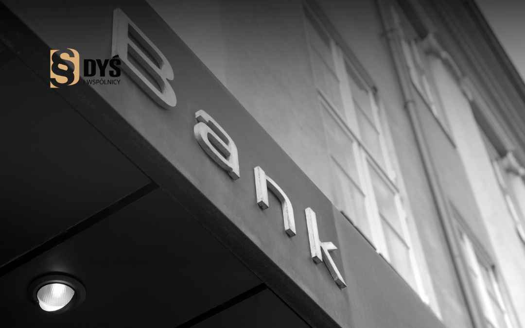 Srebrny napis Bank na fasadzie budynku – symbol sporu sądowego frankowiczów z instytucją finansową.