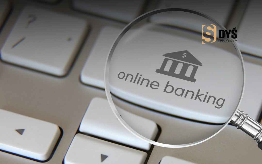 Lupa powiększająca napis online banking i ikonę banku na klawiaturze komputera.