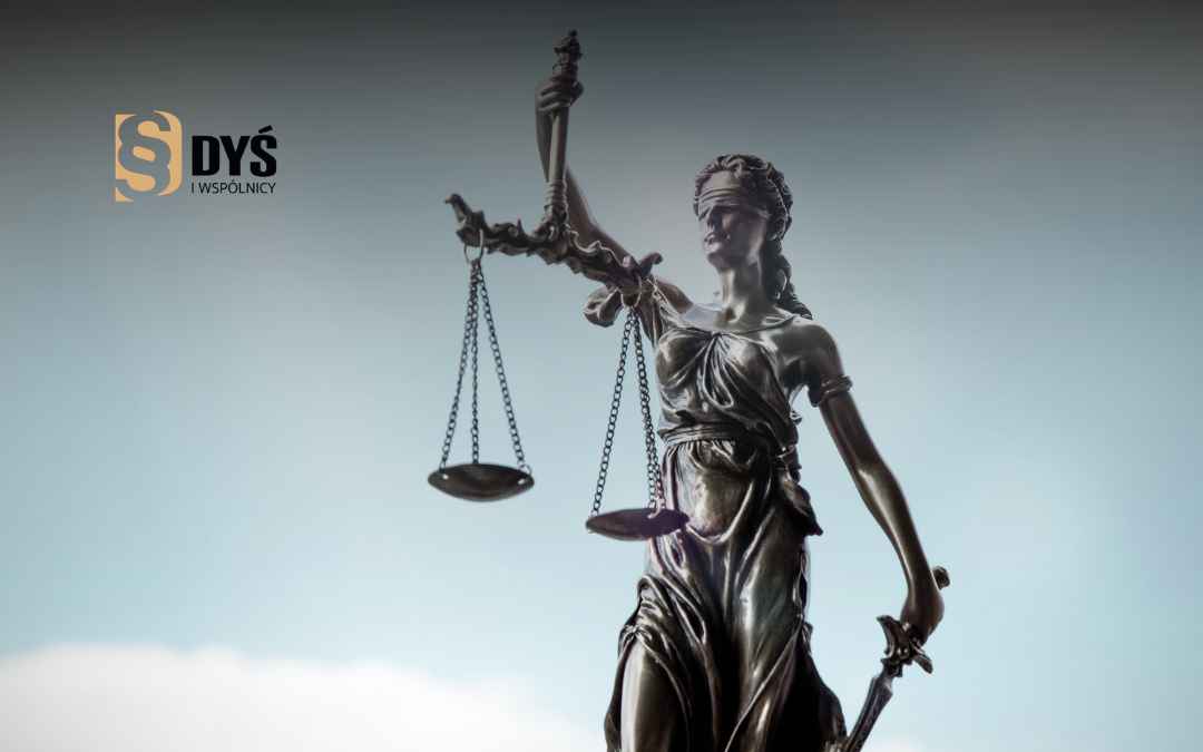 Statua Temidy z wagą i mieczem na tle nieba – symbol profesjonalnej pomocy prawnej.