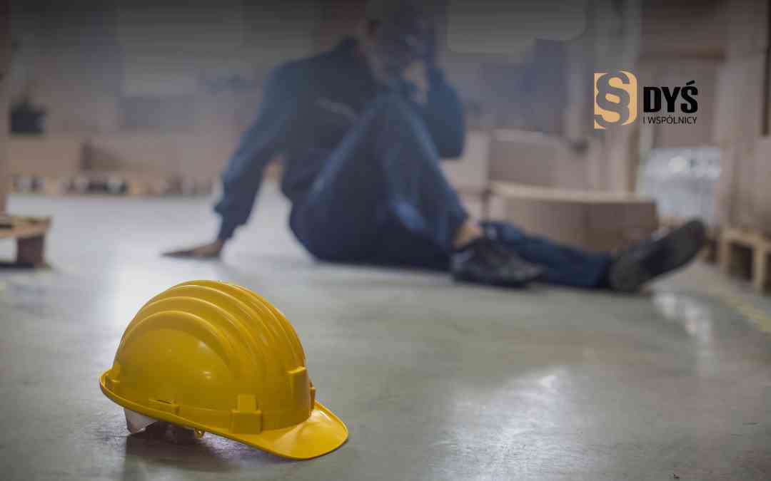 Żółty kask ochronny leżący na ziemi obok rannego pracownika magazynu – nieprzestrzeganie zasad BHP.