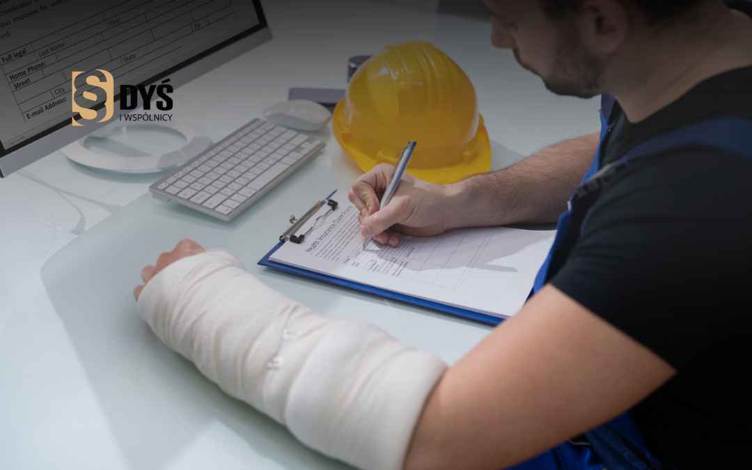 Pracownik z ręką w gipsie wypełnia formularz powypadkowy przy biurku z kaskiem.