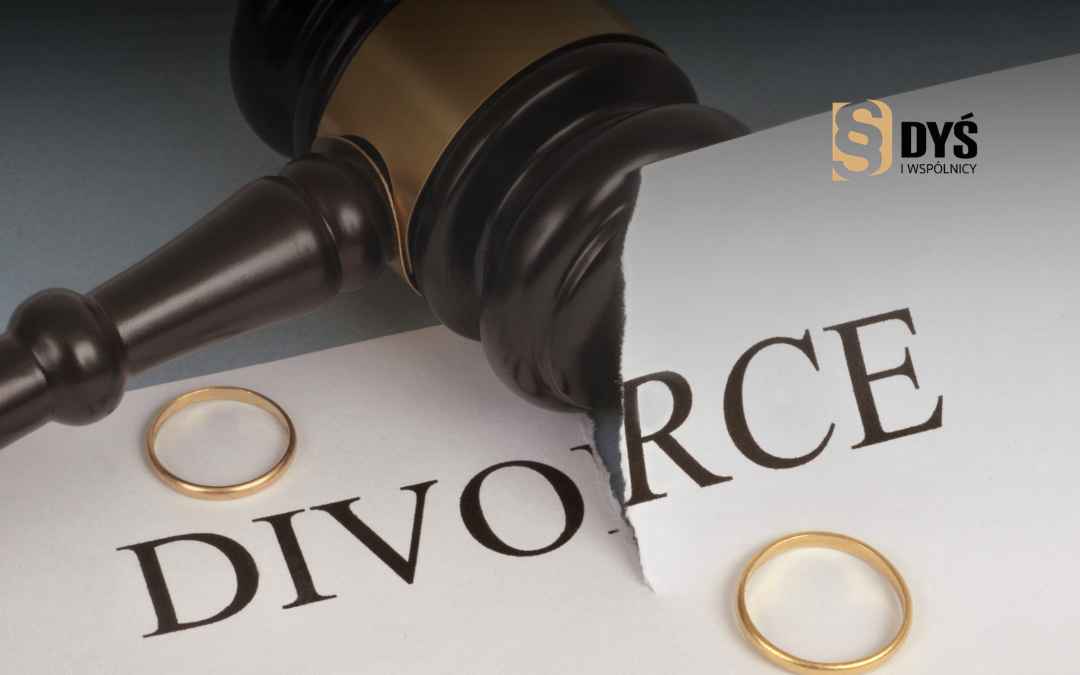 Młotek sędziowski rozcina kartkę z napisem divorce obok dwojga obrączek.
