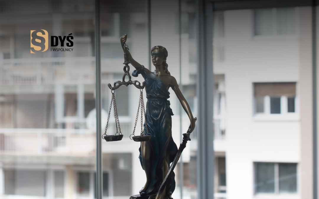 Statuetka Temidy z wagą sprawiedliwości na tle okna – symbol sądowej walki frankowiczów z bankami.