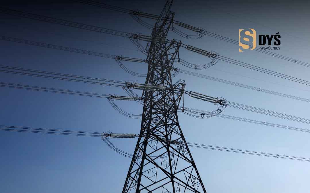 Słup energetyczny z liniami wysokiego napięcia na tle nieba.