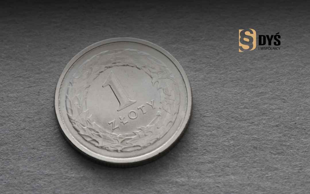 Moneta 1 złoty leży na ciemnym blacie.