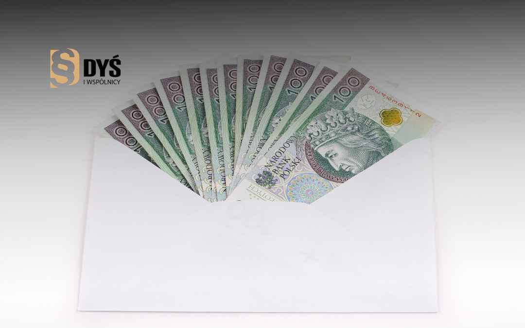 Polskie banknoty 100 PLN wyłaniające się z białej koperty.