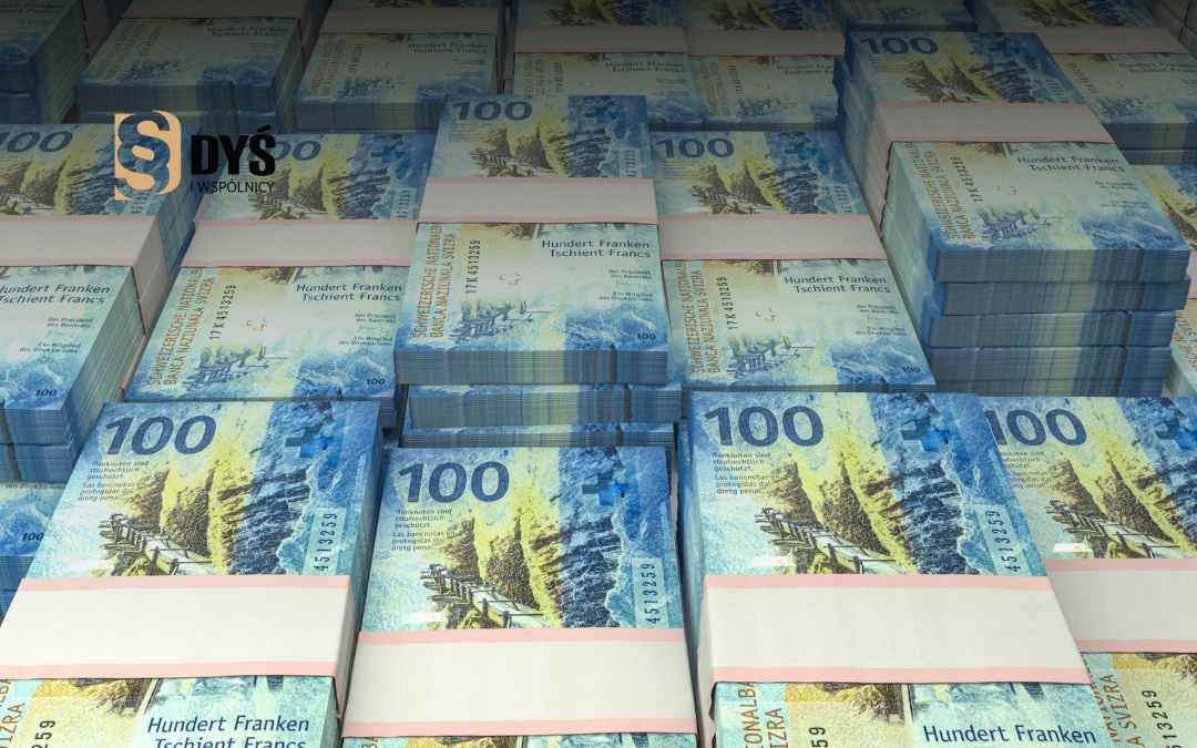 Pliki stosów banknotów sto franka szwajcarskiego symbolizujące salda i ryzyko kredytów frankowych.