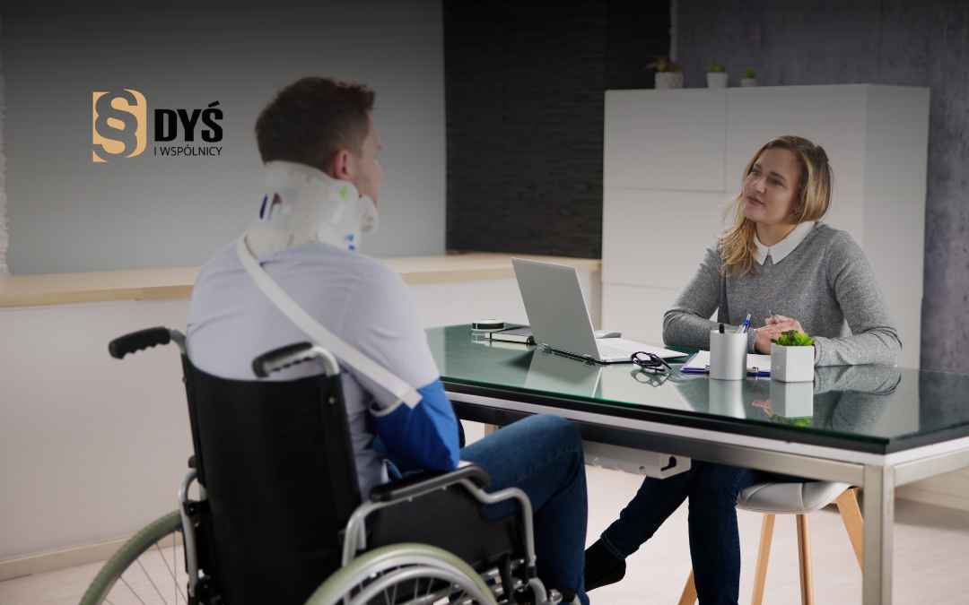 Poszkodowany na wózku inwalidzkim rozmawia z prawniczką w kancelarii o odszkodowaniu.