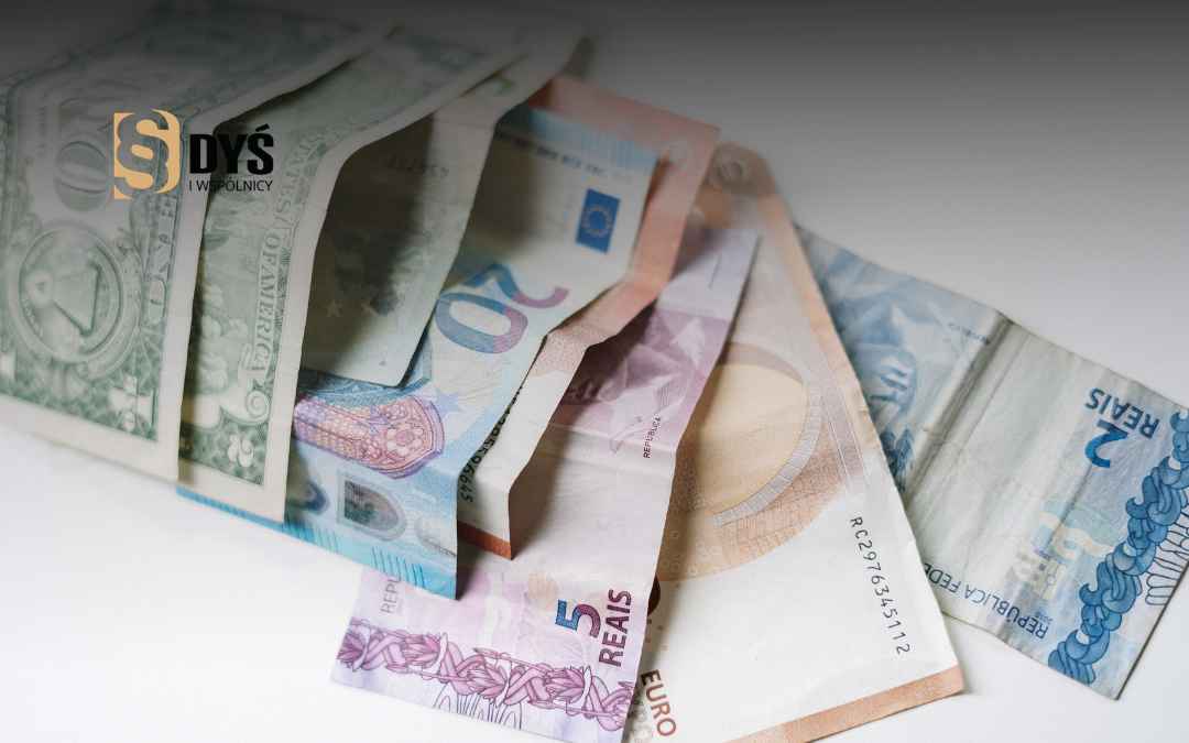 Rozłożone banknoty euro, dolarów i reali brazylijskich jako ilustracja kredytów powiązanych z walutami obcymi.