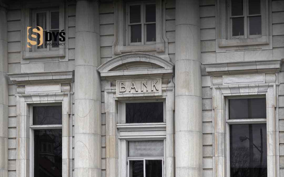 Elewacja klasycznego, kamiennego budynku z napisem „BANK”.