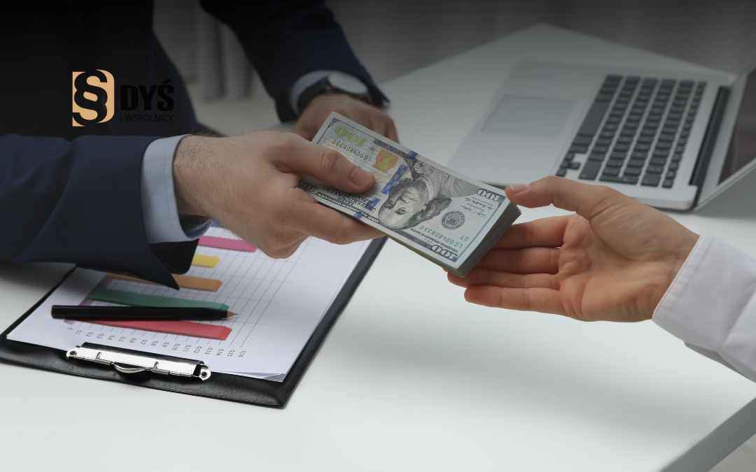 Mężczyzna przekazuje plik banknotów klientowi przy biurku – rozliczenie spłaconego kredytu USD