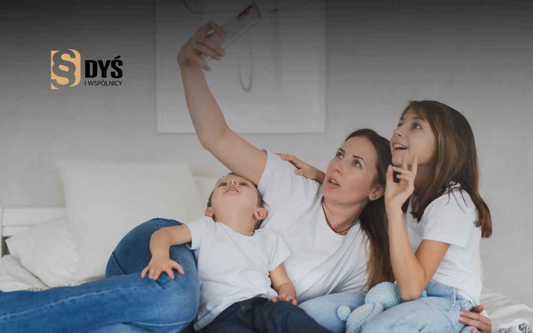 Uśmiechnięta mama robiąca selfie z dwójką dzieci.